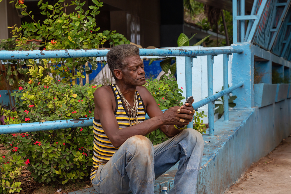 Cuban man using cell phone at a wifi hotspot on the streets in old havana