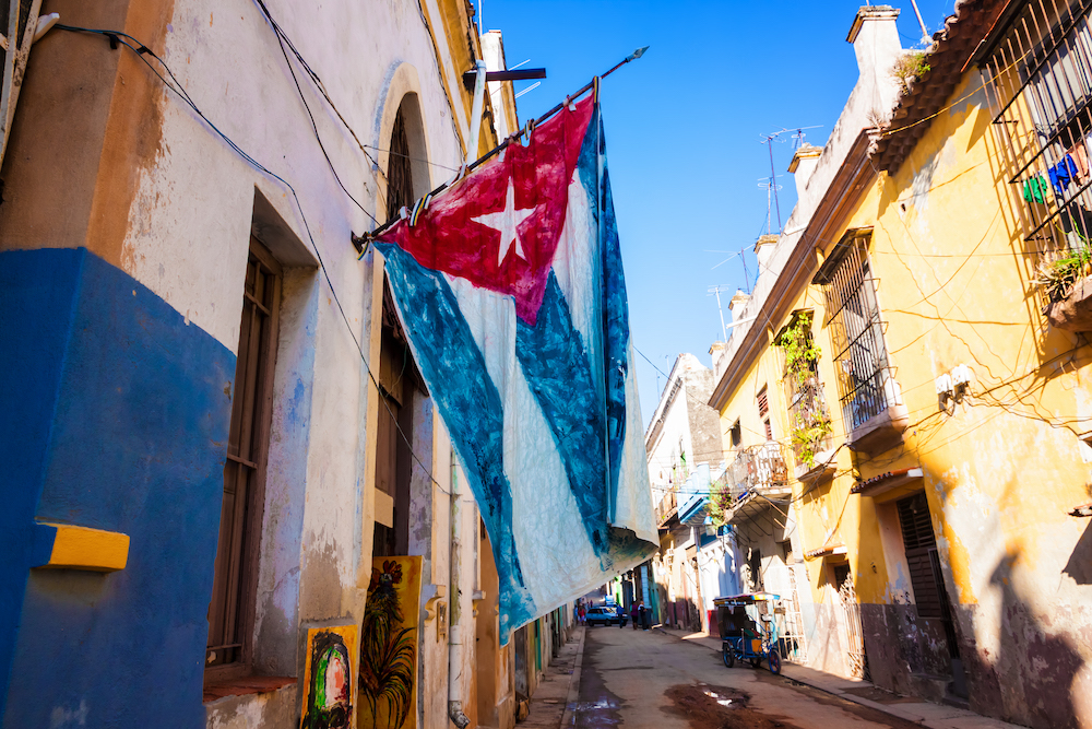 Complete travel guide for first time visitors. Side street in Old Havana with Cuban flag