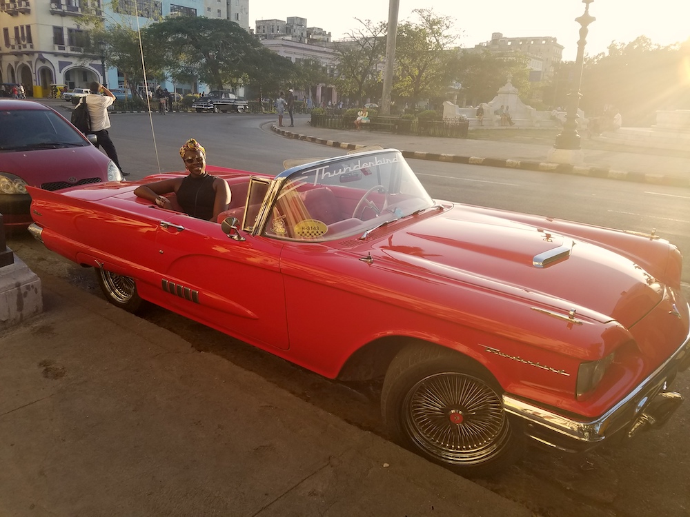 Cuba Bucket List: 10 Best Things To Do In Cuba. Lady Chin sitting in a vintage American car in downtown Havana, Cuba. 