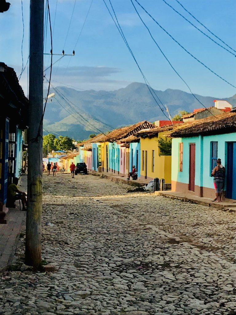 The Complete Trinidad, Cuba Travel Guide. Colorful homes in Trinidad, Cuba with views of the mountains. 