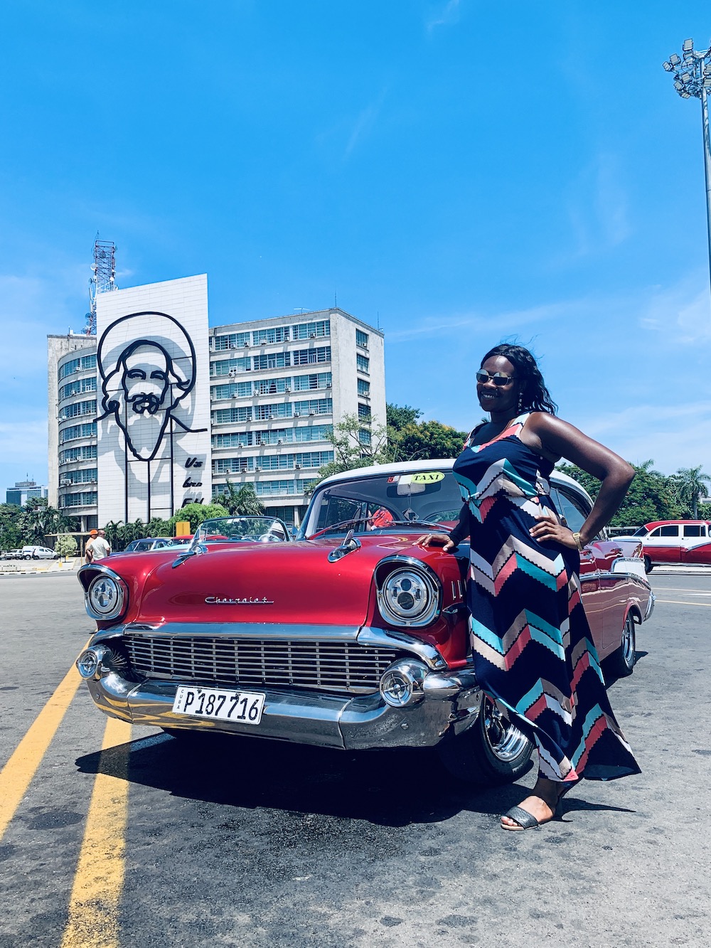 10 Things To Know Before Traveling To Cuba.  Lady Chin in Plaza de Revolucion in front of classic car.
