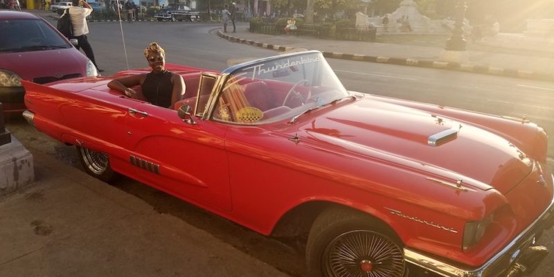 The Ultimate Cuba Travel Guide.  Lady Chin sitting in a classic American car in Havana Cuba.  Cuba Bucket List. 