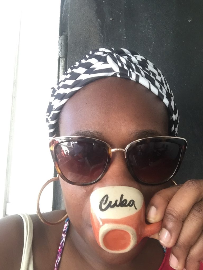 Cuba Currency Guide: Everything You Need To Know. Picture of Lady Chin drinking coffee in Playa Baracoa. 