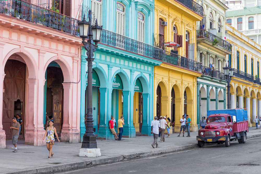 Cubans in the streets surrounded by colorful buildings in Havana, Cuba.  The largest city in the Caribbean.