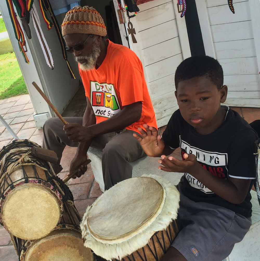 9 Ways To Experience Garifuna Culture in Belize - Young boy and elder man playin drums in Belize. 