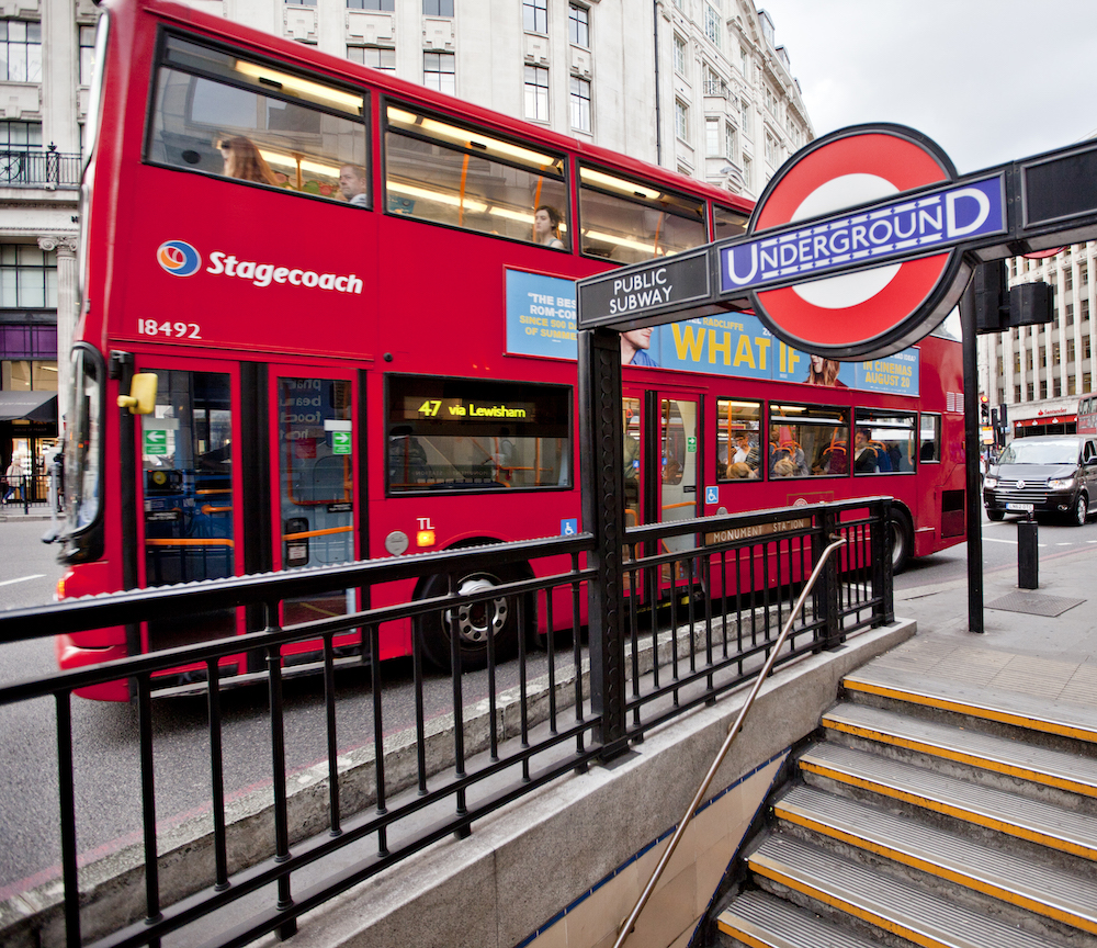 The famous London underground entrance, signage and double decker bus. 