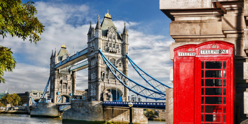 Image of the Tower Bridge and red phone booths in Central London, England, UK.