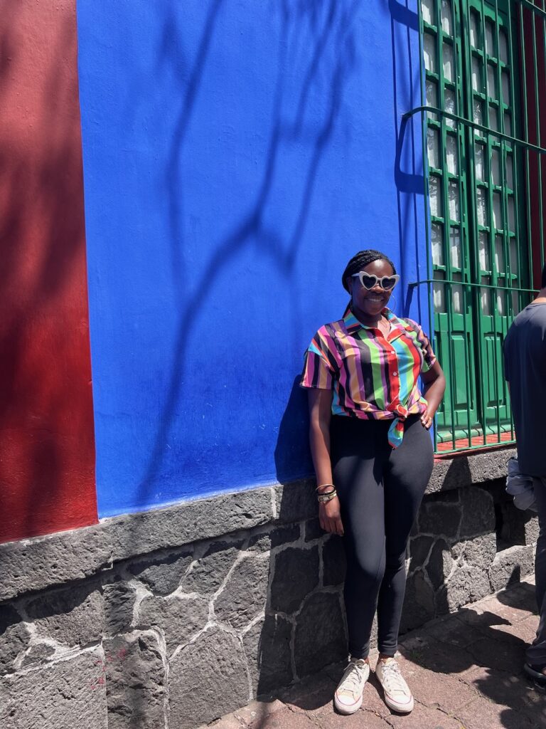 Picture of Lady Chin standing in front of the La Casa Azul in Coyoacán, Mexico.