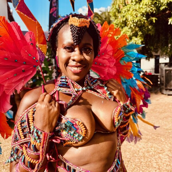 Black women at Trinidad Carnival 2024 dressed in colorful costume with elaborate sequins and feathers in Flamenco section with Tribe Carnival.