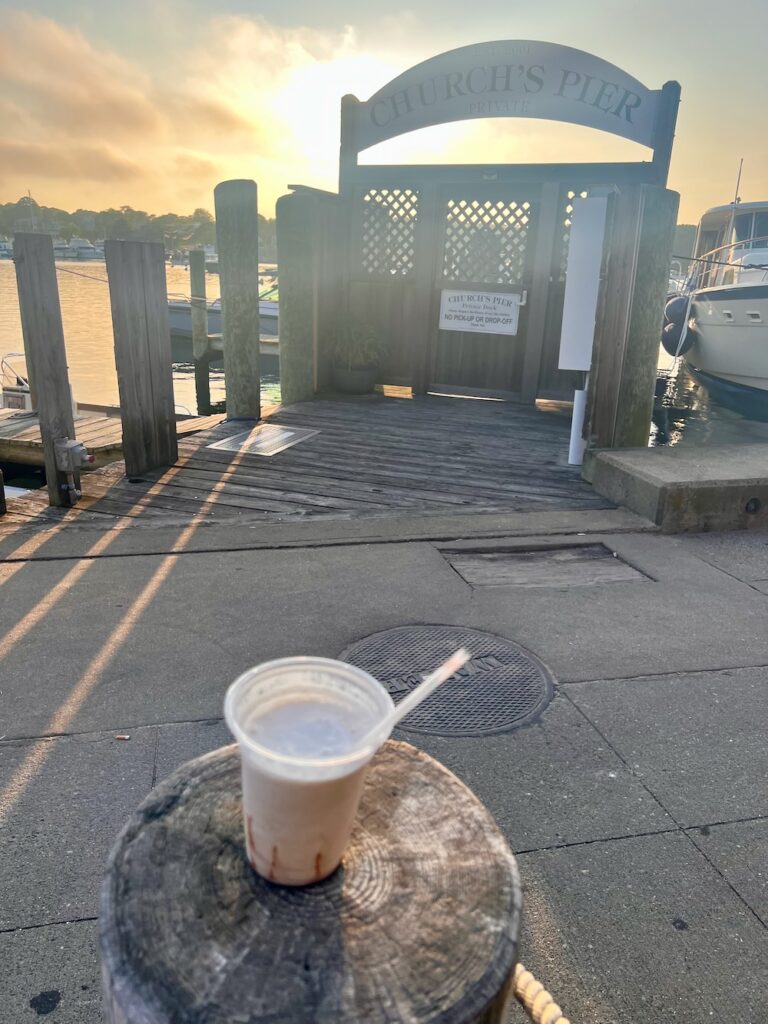 Dirty banana drink in front of church's pier in Oak Bluffs with the sun setting in the back ground. 