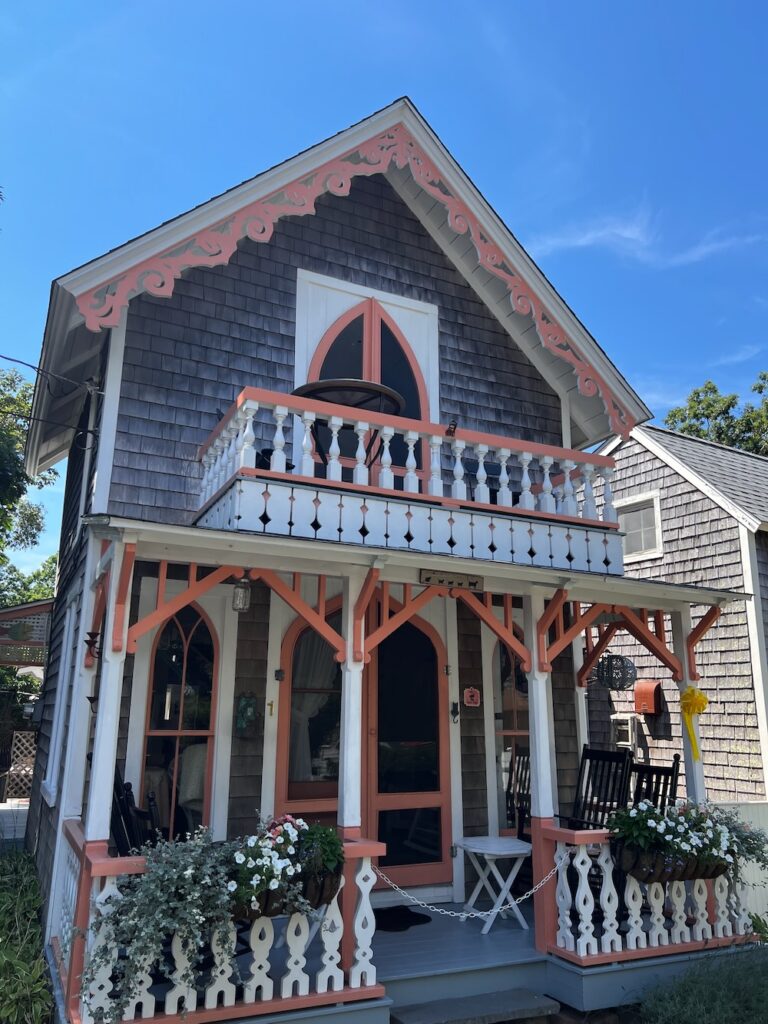 Pink, white and grey gingerbread house with white and green flowers in Oak Bluffs, Martha's Vineyard. 