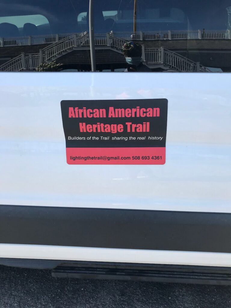 African American heritage trail sticker in red writing on a white bus. 