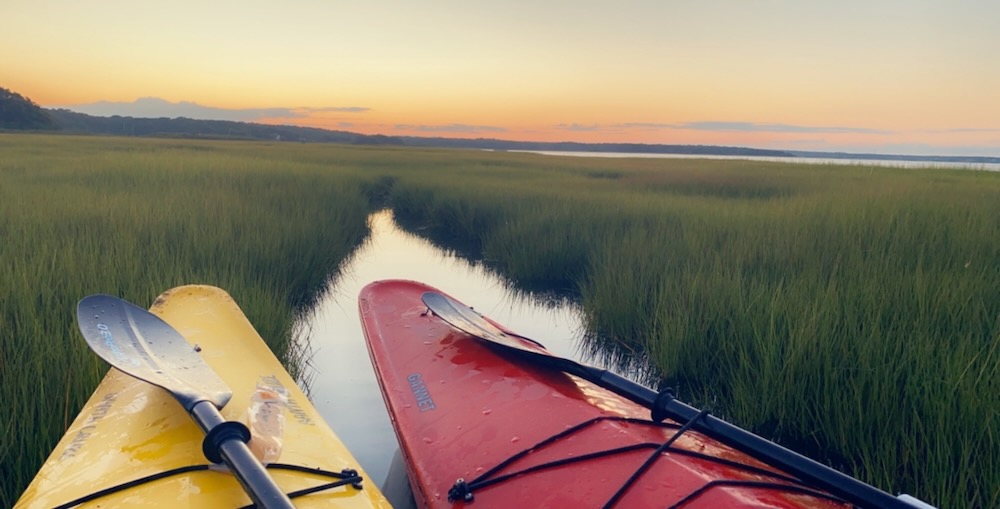 Yellow and red kayak in a pond overlooking the sunset. 