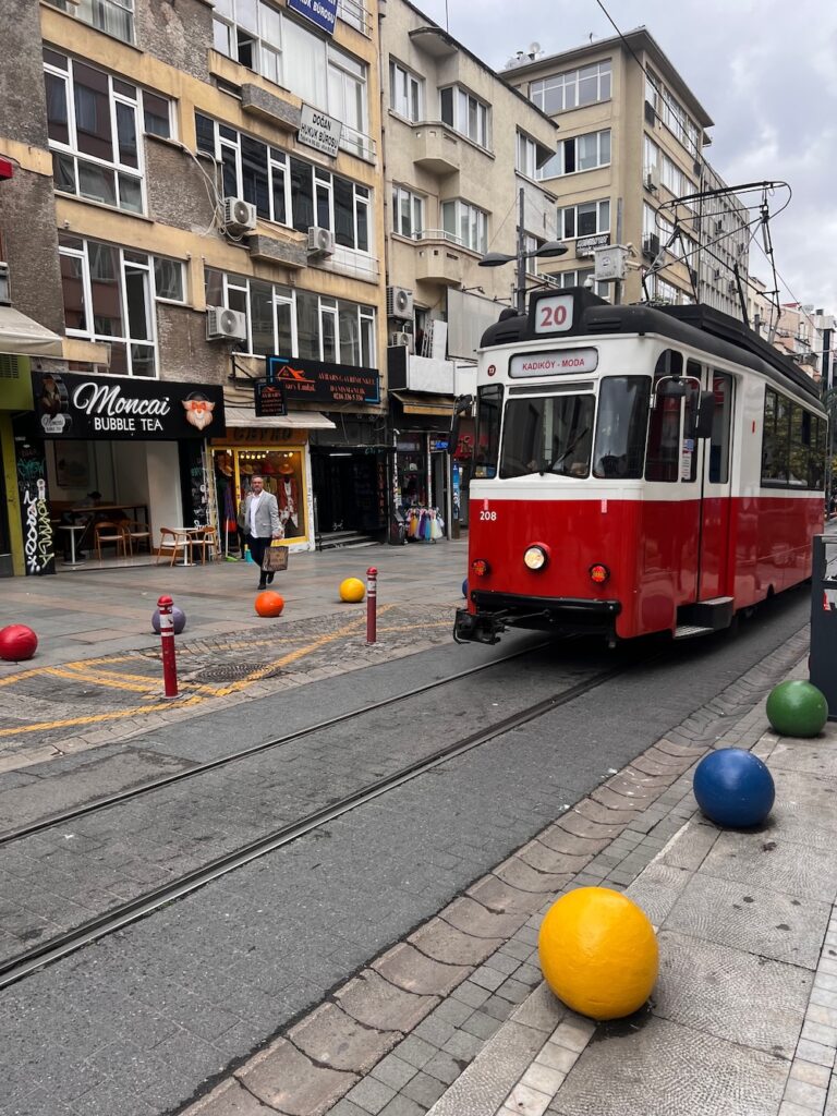 Red and white trolley moving down the street in Kadikoy, Istanbul, Turkey
